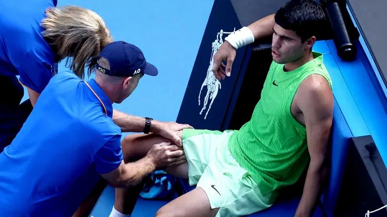 O espanhol Carlos Alcaraz recebe atendimento médico durante a semifinal masculina contra o alemão Alexander Zverev no Australian Open, em Melbourne, em 30 de janeiro de 2026. (Foto: David Gray/Afp)
