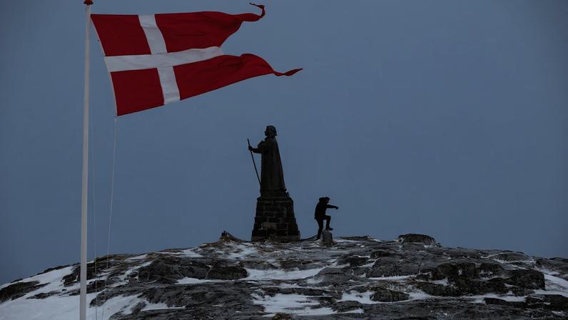 A man walks as Danish flag flutters next to Hans Egede Statue in Nuuk, Greenland, March 9, 2025. REUTERS/Marko Djurica/File Photo