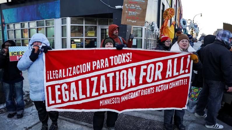 People hold a banner during a demonstration against the presence of federal immigration agents in Minneapolis, Minnesota, U.S., January 28, 2026.