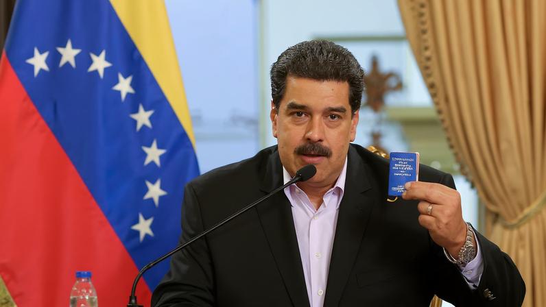 Venezuela's President Nicolas Maduro holds a copy of the Venezuelan constitution while he speaks during a meeting with members of the Venezuelan diplomatic corp after their arrival from the United States, at the Miraflores Palace in Caracas, Venezuela January 28, 2019. Miraflores Palace/Handout via REUTERS/File Photo