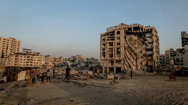 People walk past a heavily damaged building in Gaza City on Nov. 10, 2025.