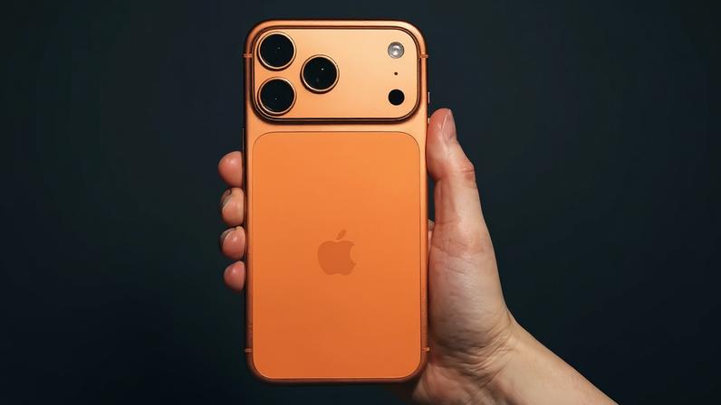 Krakow, Poland - November 6, 2025. Close-up editorial image shows a hand holding the latest Apple iPhone 17 Pro Max in Cosmic Orange, against a black background, highlighting the phone’s unique colour and camera design. The shot captures current consumer technology trends and the distinct design choices of Apple devices. This editorial photo is suitable for articles, reviews, and technology news related to smartphones, Apple products, or mobile innovation. (Getty Images)