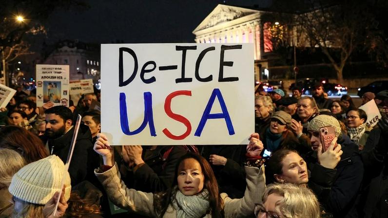A protester holds a placard that reads “De-ICE USA” during a rally in front of Paris’s National Assembly.