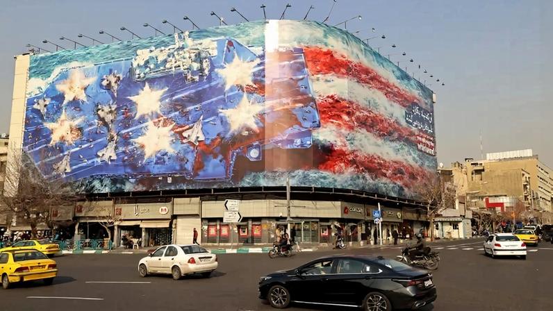 Cars drive past an anti-U.S. billboard in Tehran.