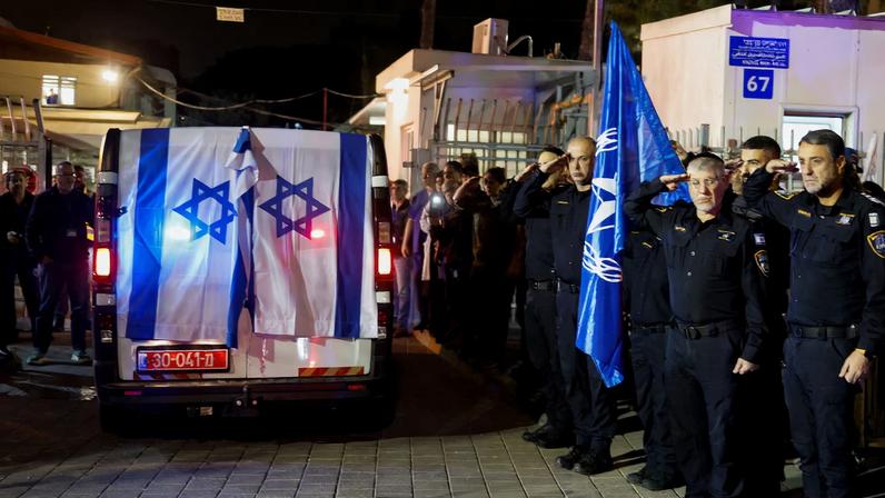 Police officers salute as the vehicle carrying the body of Israeli police officer, and the last hostage Ran Gvili, kidnapped in the October 7, 2023, Hamas attack, arrives to the Institute of Forensic Medicine after being found and identified, in Tel Aviv