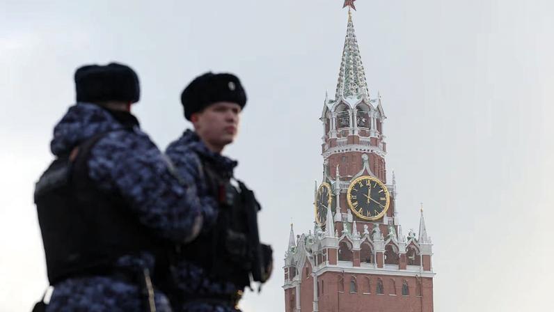 Russian law enforcement officers stand guard near Kremlin's Spasskaya Tower in Moscow