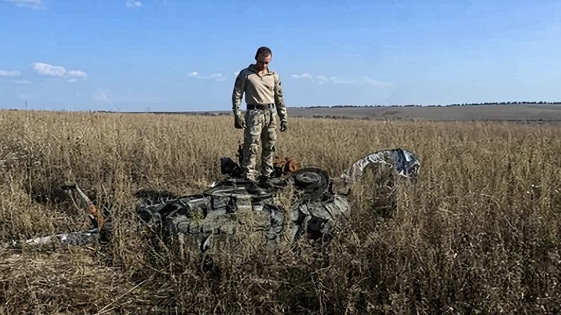 O voluntário Jan Artyukhov inspeciona um tanque russo destruído em um campo próximo à cidade de Derhachi, região de Kharkiv, em 1º de outubro de 2023