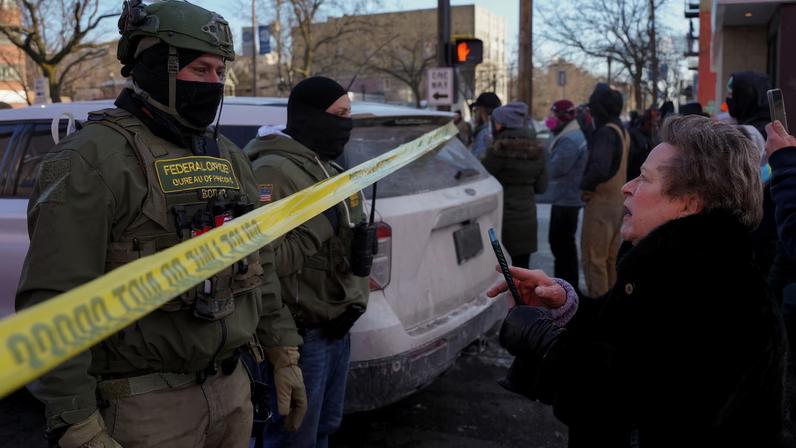 Federal agents stand behind police tape as people gather near the site where a man identified as Alex Pretti was fatally shot by federal agents trying to detain him, in Minneapolis, Minnesota, U.S., January 24, 2026. REUTERS/Seth Herald/File Photo