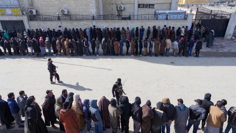 Members of the Kurdish-led Syrian Democratic Forces (SDF) queue to settle their status with Syrian government in Raqqa