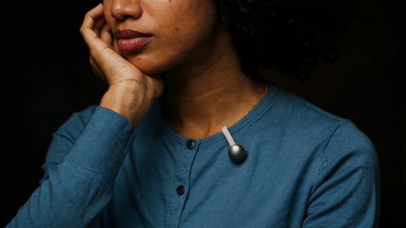 The SwitchBot AI MindClip, worn clipped to a person’s shirt.