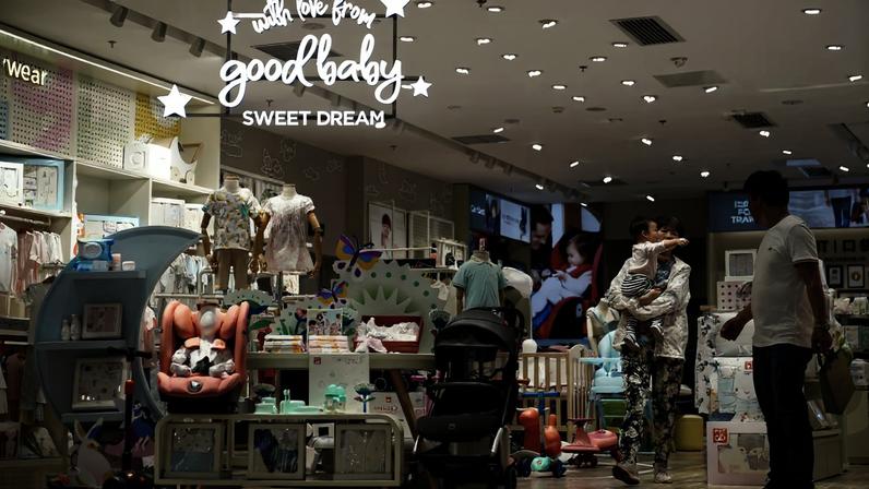 Adult holding a baby walks at a store selling baby products in Shanghai
