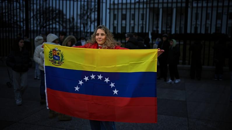 Mulher exibe a bandeira da Venezuela em frente à Casa Branca (Foto: Mandel Ngan/AFP)