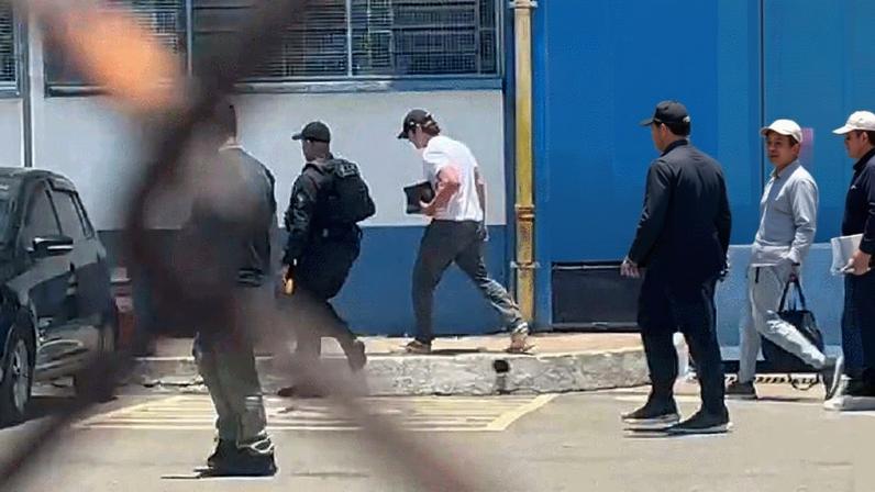 Daniel Vorcaro (no destaque) deixa a prisão usando boné e camiseta branca — Foto: Reprodução/Arquivo pessoal e Bruna Vieira/TV Globo