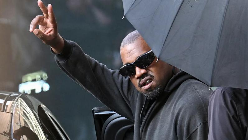 TOPSHOT - US rapper and producer Kanye West gestures upon arriving at Shanghai Pudong International Airport on July 11, 2025. Kanye West will hold a concert in Shanghai on July 12. (Photo by Hector RETAMAL / AFP) (Photo by HECTOR RETAMAL/AFP via Getty Images)