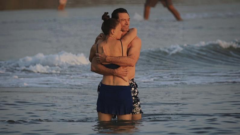 Hugh Jackman and Sutton Foster packed on the PDA while taking a sunset dip in the ocean.