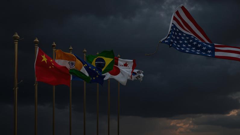 An illustration shows one empty flagpole alongside the flags of multiple countries. The U.S. flag is seen at far right, untethered, flying out of frame.