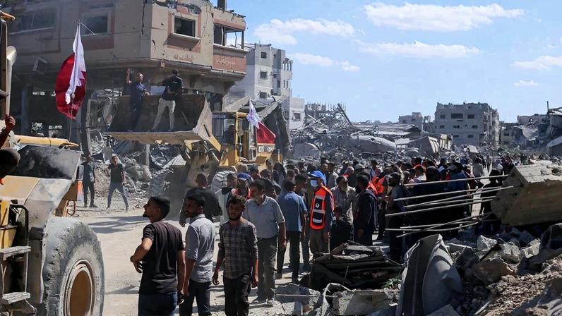 Palestinos com escavadeiras tentam limpar os destroços da guerra das ruas de Gaza. Foto: AFP