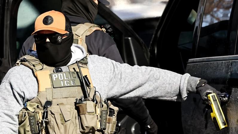 Um agente do ICE, a polícia de imigração nos EUA, cobre o rosto com uma máscara durante uma operação. Foto: Charly TRIBALLEAU / AFP
