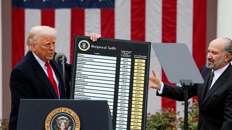 Presidente dos EUA, Donald Trump, segura quadro com dados sobre tarifas ao lado do Secretário de Comércio, Howard Lutnick, na Casa Branca, em Washington