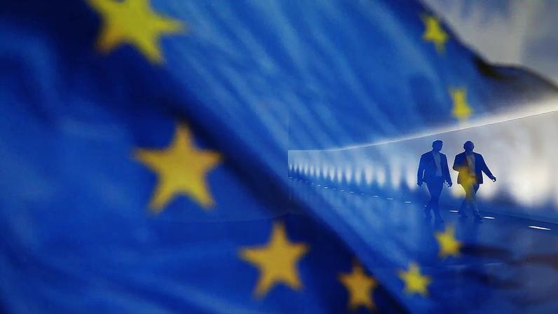 People walk by a European Union flag in the Bundestag in Berlin on June 26, 2024, ahead of a European Council summit.