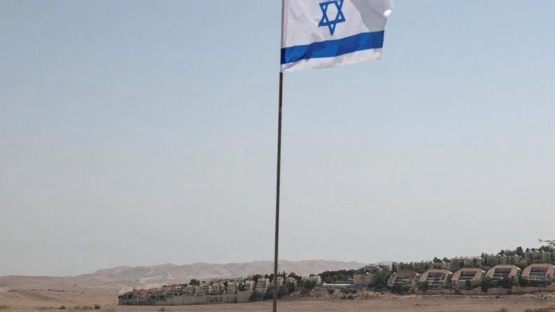 An Israeli flag flutters, as part of the Israeli settlement of Maale Adumim is visible in the background, in the Israeli-occupied West Bank, August 14, 2025. REUTERS/Ronen Zvulun