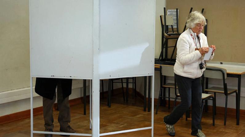 A woman walks from a voting booth during the presidential election in Lisbon, Portugal, January 18, 2026. REUTERS/Pedro Nunes