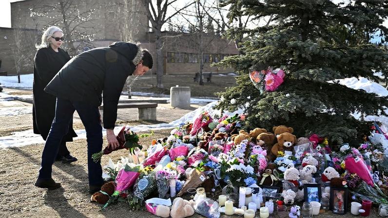 British Columbia Premier David Eby lays flowers next to Nina Krieger, British Columbia Minister of Public Safety and Solicitor General, at a makeshift memorial for the victims, two days after a deadly mass shooting took place at a school in the town of Tumbler Ridge, British Columbia, Canada, February 12, 2026. REUTERS/Jennifer Gauthier