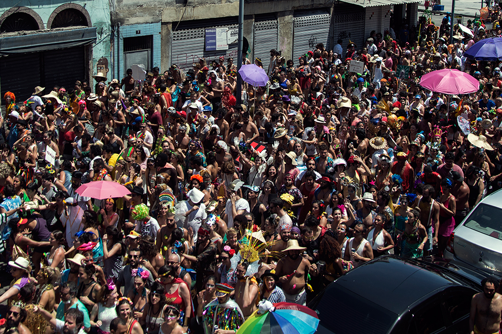Fotografia de um bloquinho de carnaval lotado de pessoas.
