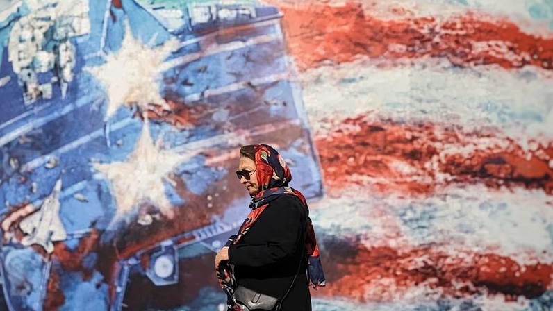 An woman walks past an anti-US billboard in Tehran.