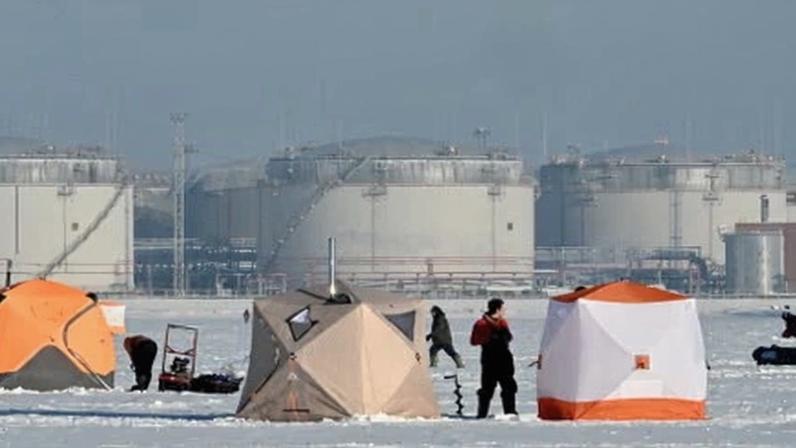 Russian fishers at work in front of an oil terminal in the port of Saint Petersburg.