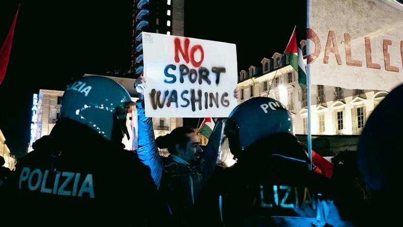 Police surround a protester holding a sign that reads "No Sport Washing." Demonstrators protest against sportswashing and the participation of Israel in the Winter Olympics in Turin, Italy, on Jan. 11. Elisa Marchina/NurPhoto/Reuters