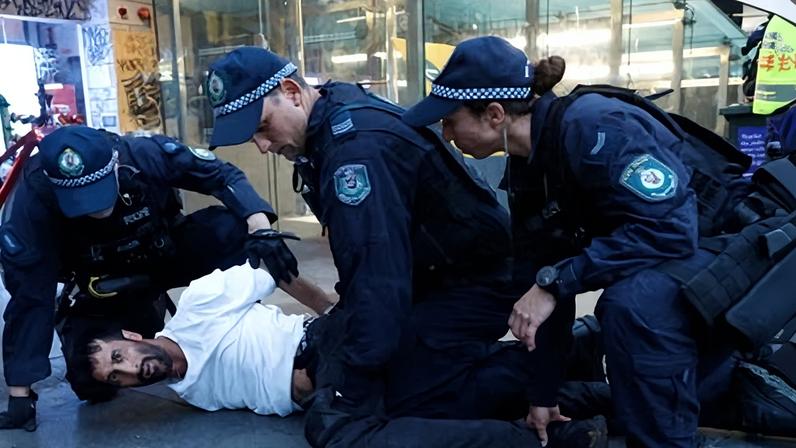 NSW police detain a protester against Israeli president Isaac Herzog’s visit outside Town Hall in Sydney last night.