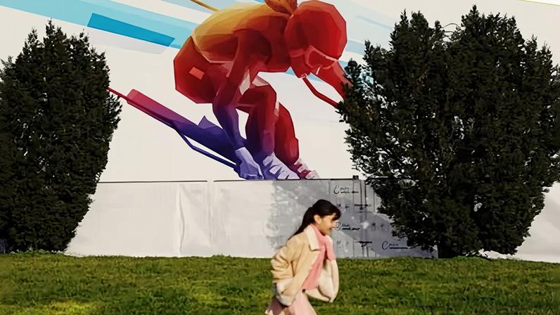 A child runs past artwork featuring an alpine ski athlete at Sforzesco Castle on 1 February 2026.