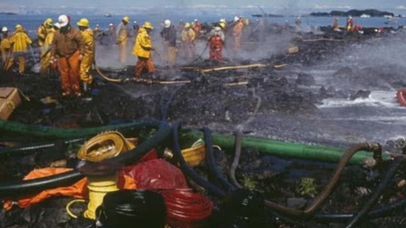 Teams of firefighters cleaning the Alaskan coast after the 1989 Exxon Valdez oil spill.
