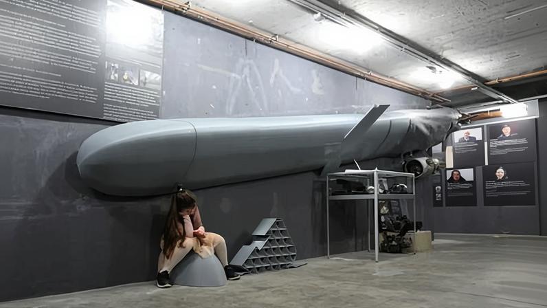 A young visitor sits underneath a reconstruction of a Russian cruise missile, intended to give a sense ‘of how big it is when it’s flying towards you’. Photograph: Ralf Hirschberger/AFP/Getty Images