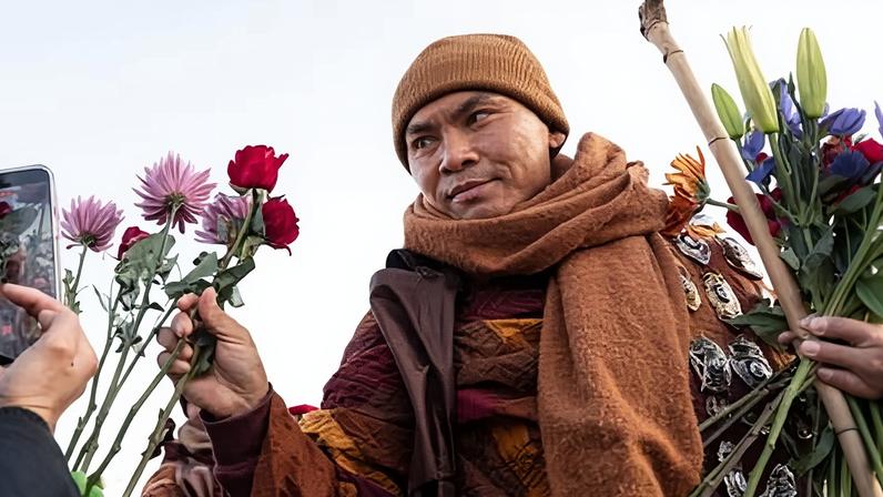 The venerable Bhikkhu Pannakara accepts an offering of a flower as he leads the Buddhist monks during the peace walk in Woodbridge, Virginia.