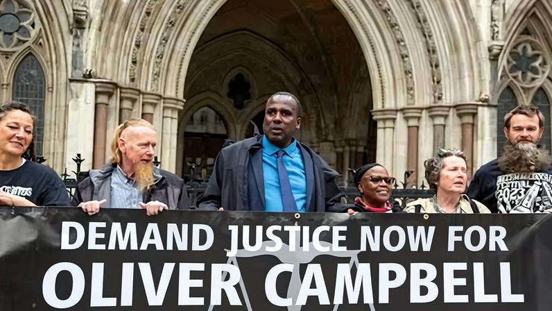 Supporters join Oliver Campbell, centre, who cleared his name after spending 11 years of a life sentence in jail, at the Royal Courts of Justice last May.