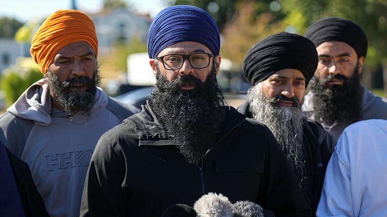 Moninder Singh, centre, speaking to reporters in 2023 in Surrey, British Columbia.