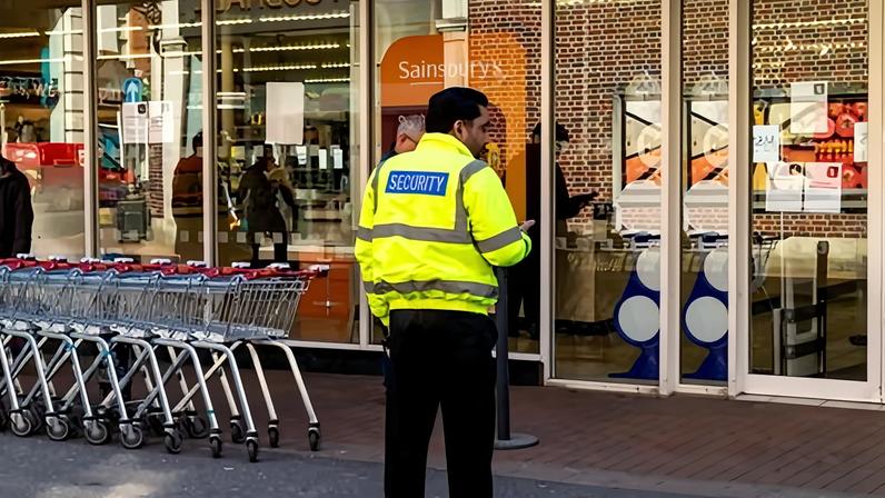 A security guard at a supermarket in Winchester, Hampshire. Retailers said investment in more security staff had cut violence and abuse against retail workers.