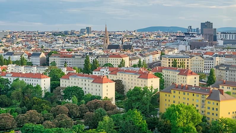 View of the skyline of Vienna with the trees of the Prater park in the foreground.