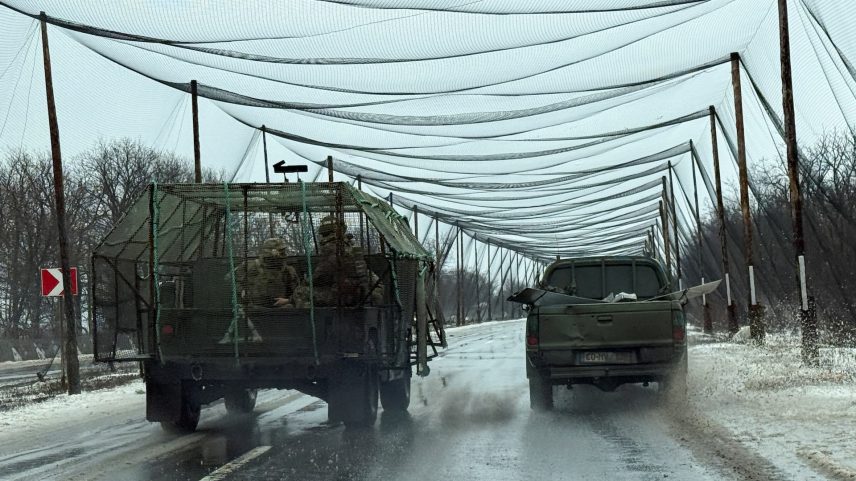 Service members of the 93rd Kholodnyi Yar Separate Mechanized Brigade of the Ukrainian Armed Forces ride a military vehicle, with a grille installed for combat drones protection, along a road covered with anti-drone net, amid Russia's attack on Ukraine, near the frontline town of Kostiantynivka in Donetsk region, Ukraine February 19, 2026. Picture taken with a mobile phone.
