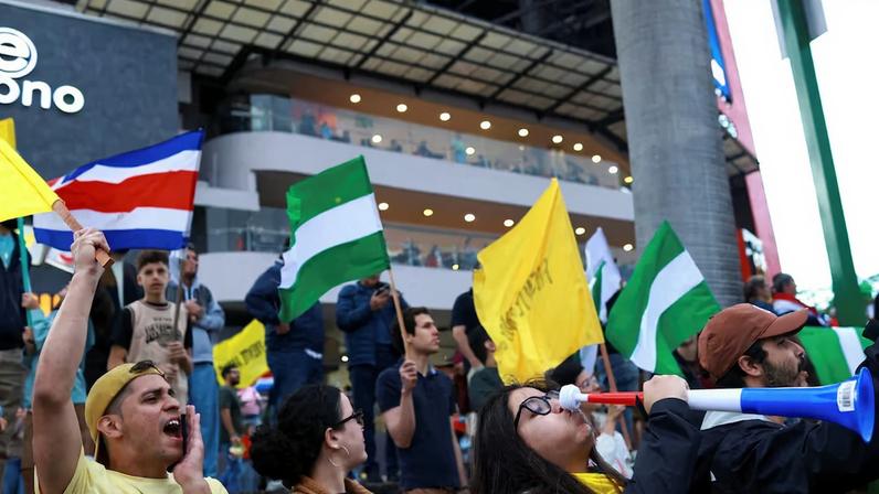 People wave flags ahead of Sunday's elections, with polls indicating Laura Fernandez of the Sovereign People's Party (PPSO) as the clear frontrunner, amid a surge in drug trafficking and violence that has eroded the country's image as a peaceful tourist haven