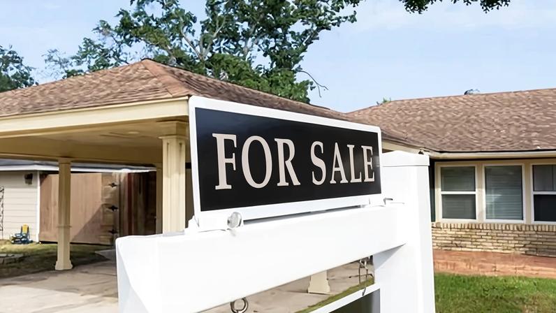 A for sale sign is seen in front of a house in a Spring Branch neighborhood in Houston last year.