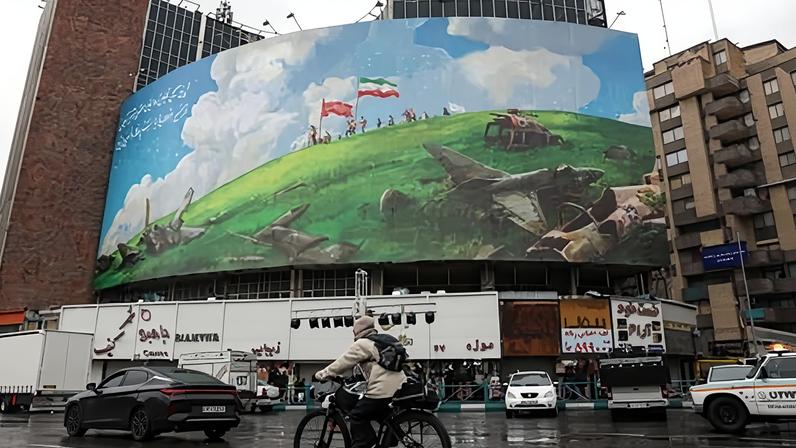 A cyclist rides past an anti-US billboard in Tehran. Iran and the United States are scheduled to hold talks on Friday in Muscat, Oman, amid a recent US military build-up in the Middle East. Follow the latest developments, live.