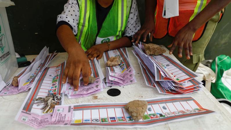 Electoral officials use stones to hold down ballots during the vote counting process of the gubernatorial election at a polling unit in Lagos, Nigeria March 18, 2023. REUTERS/Temilade Adelaja