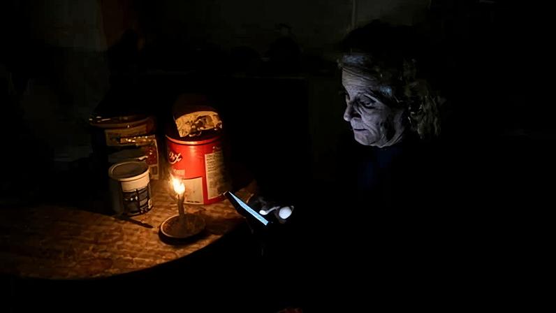 A woman checks her cellphone during a blackout in Havana on 28 January 2026.