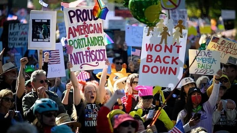 Demonstrators cheer during a speech as protesters gather to march for the No Kings protest on 18 October 2025 in Portland, Oregon.