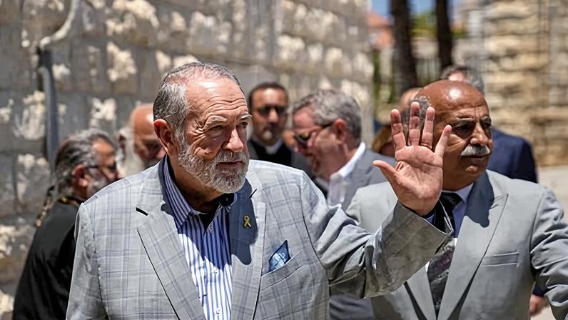 The US ambassador to Israel, Mike Huckabee, waves upon his arrival in the West Bank town of Taybeh, in 2025.