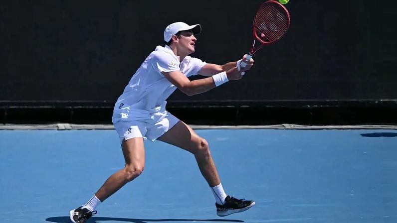 João Fonseca se estica todo para devolver a bola contra o americano Eliot Spizzirri no Australian Open (Foto: WILLIAM WEST / AFP)