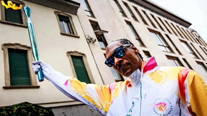 Snoop Dogg carregando a tocha olímpica em Gallarate, antes dos Jogos de Milão-Cortina 2026 (Foto: Handout/Milano Cortina 2026 Olympic Committee/AFP)
